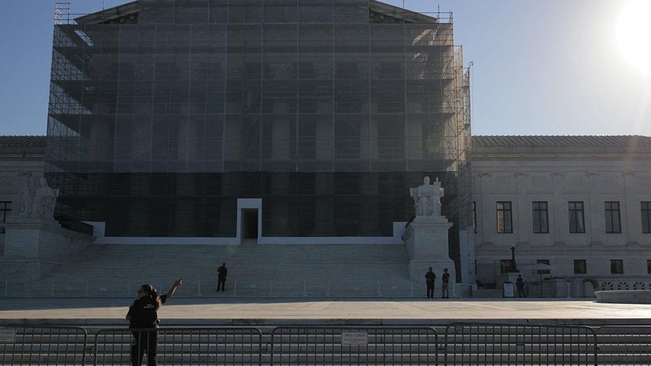 U.S. Supreme Court Police direct visitors from behind security barriers in front of court building, which is obscured in construction scaffolding, on the first day of the Court’s new term on October 06, 2025 in Washington, DC.  