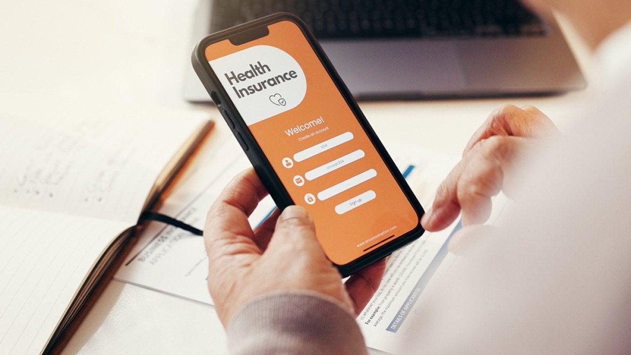 A senior person browsing a health insurance app on a smartphone.