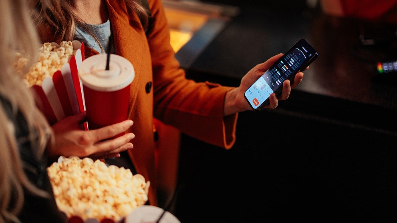 A young woman checking seats in a theater using a mobile app.