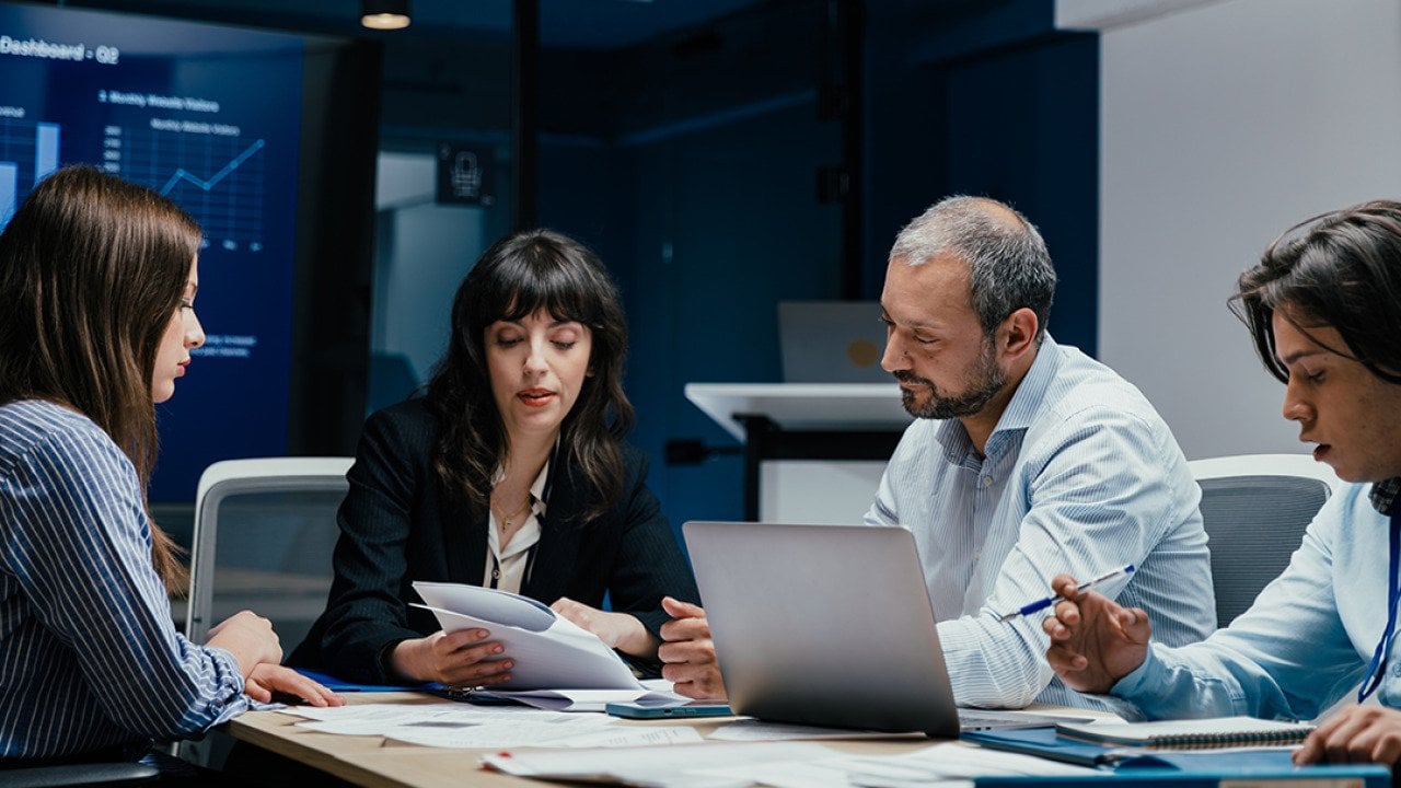 A group of business executives brainstorming in a boardroom.