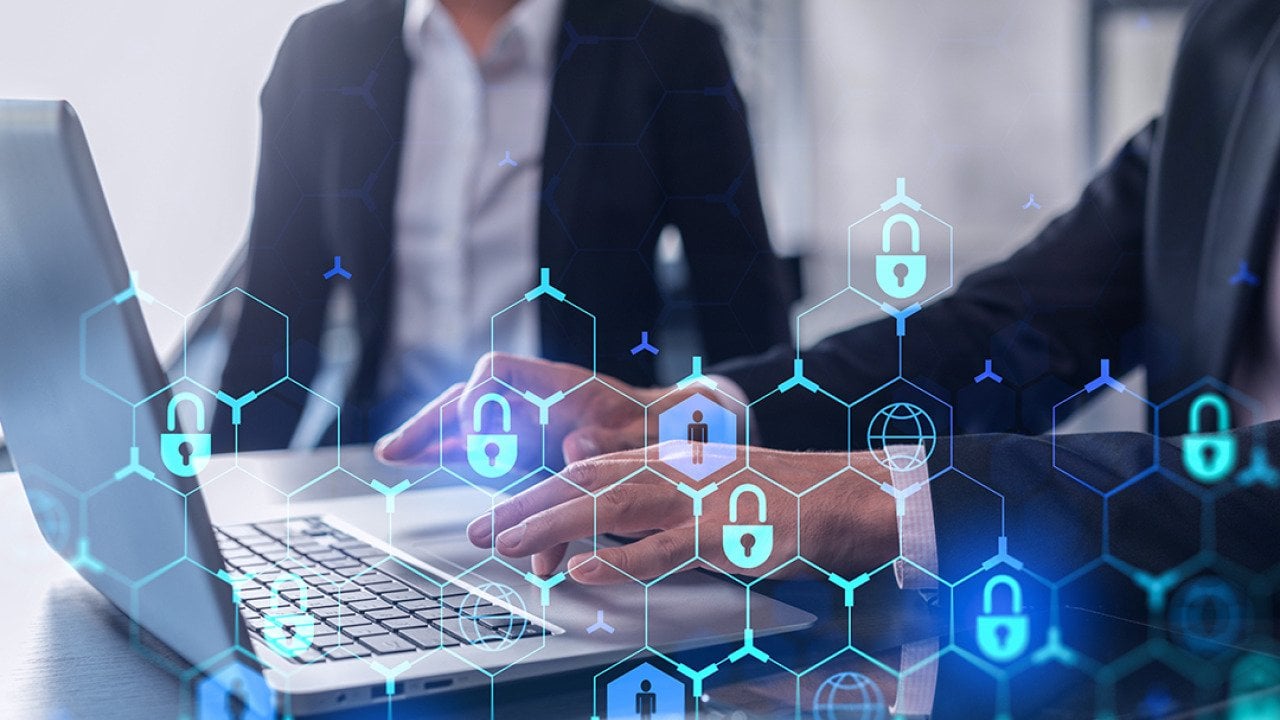 Two businesspeople in formal wear working on a project, with cyber security technology graphics illustrated.