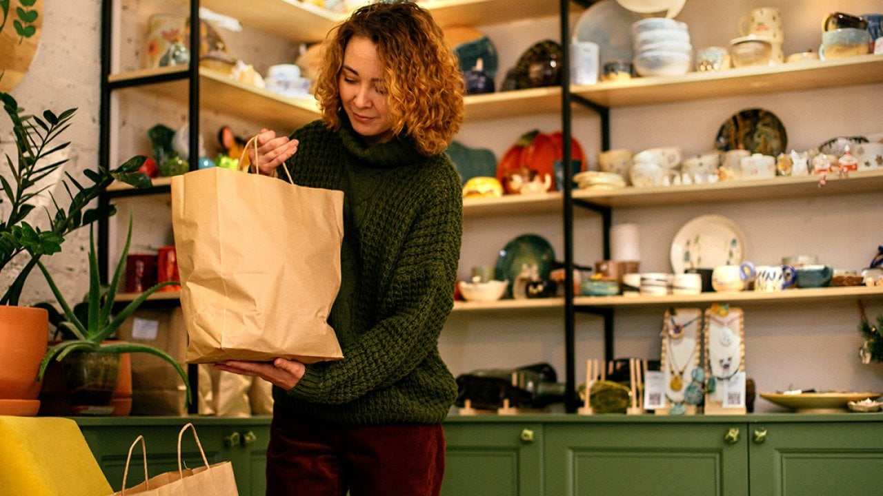 A woman packing sustainable gift items for Christmas.