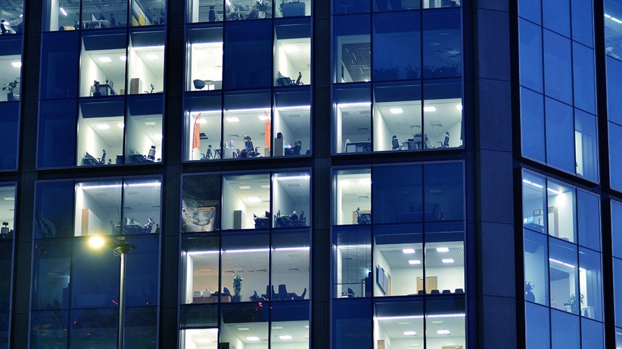 Glass facade of a modern corporate building during night.