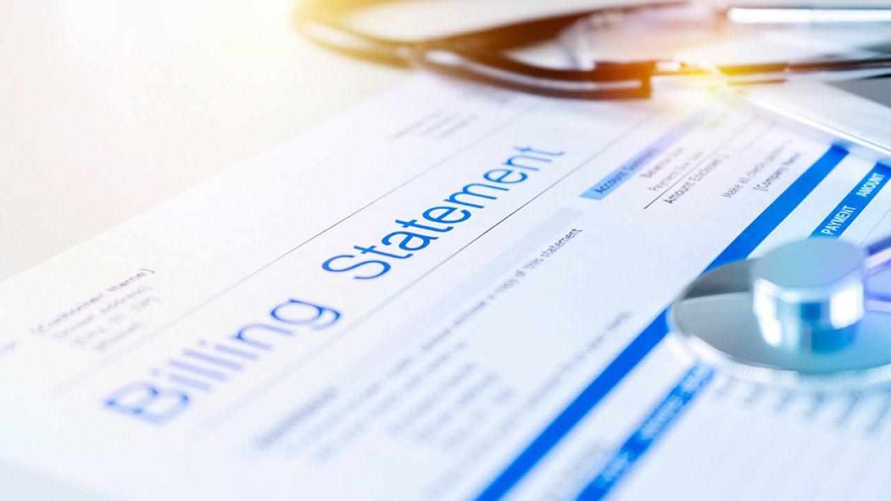 A close up on a healthcare billing statement document with a stethoscope on top.