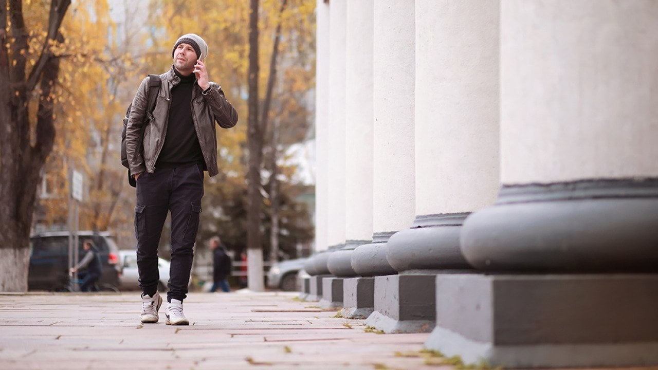 A man walking through the city during autumn.