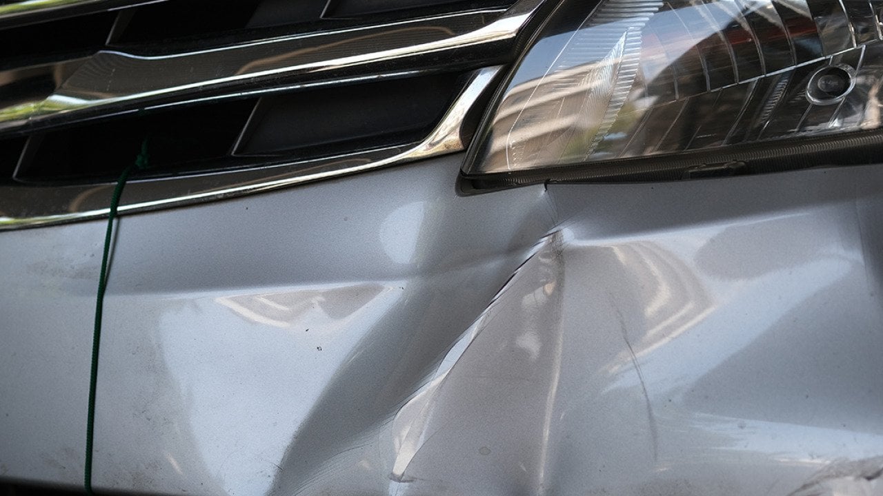 A car's bumper dented from a hit.