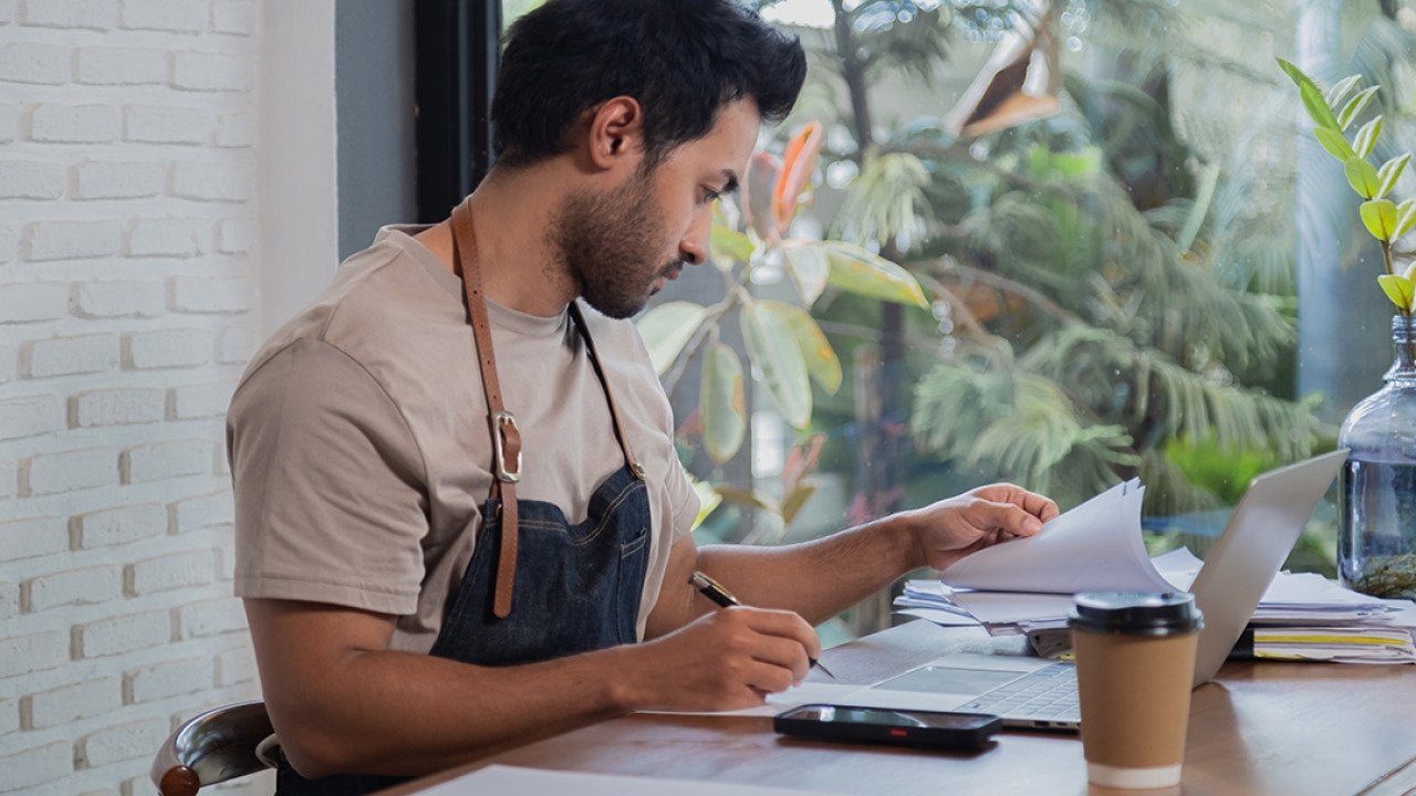 A small restaurant business owner working on tax documents.