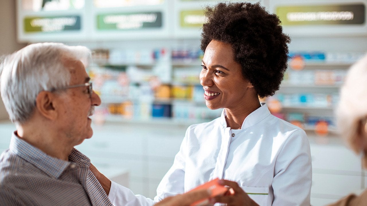 A female pharmacist helping senior customers.