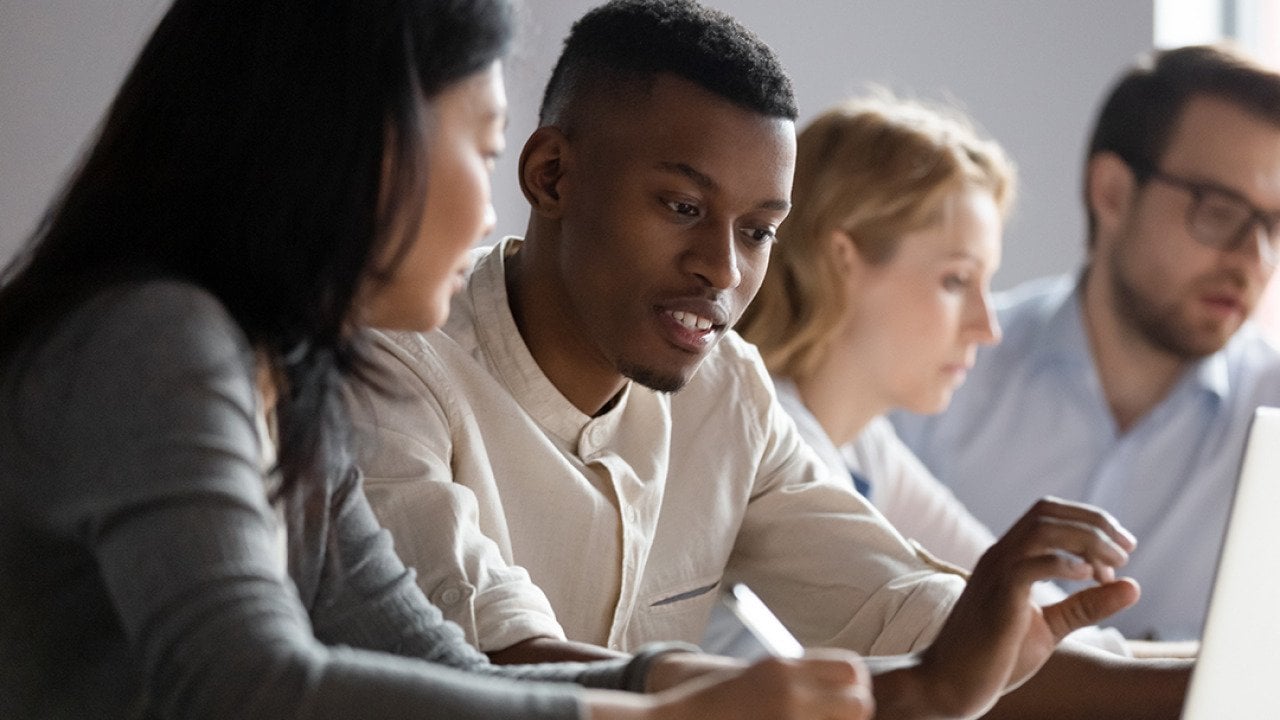 Colleagues seated at a desk in a co-working room.