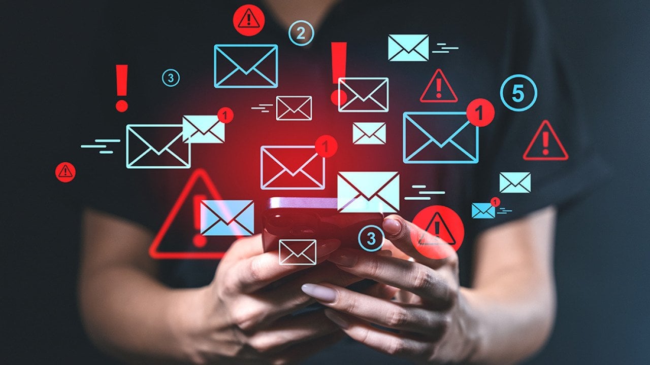 Person using a smartphone illustrated with blue and red email alert graphics.