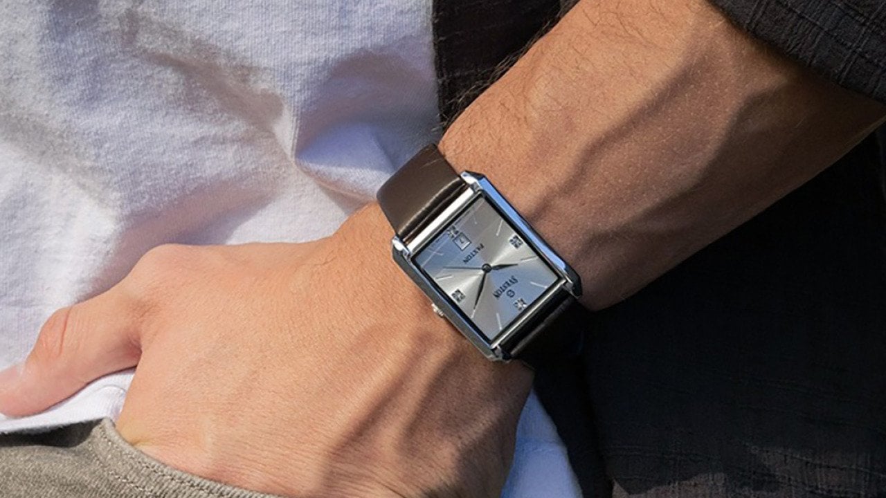Close up on a man's wrist sporting a square watch.
