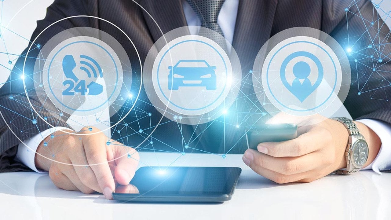 Person wearing business suit and fancy watching with face not showing looking at tablet and smartphone, with icons of cars, 24 hour phone service and agent superimposed symbolizing AI services.