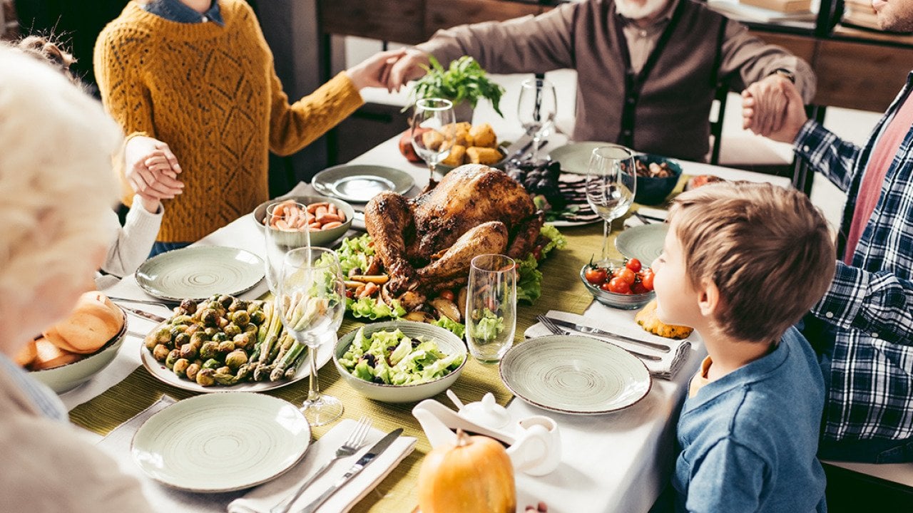 A family praying over their holiday dinner.