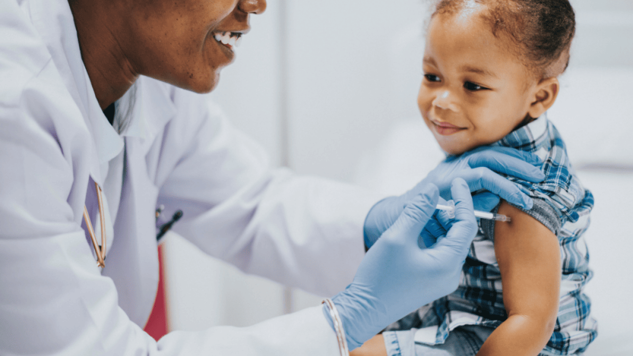 A pediatrician giving a toddler a vaccination.