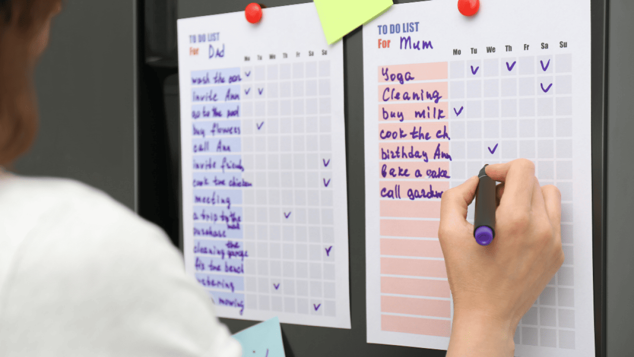 A person checking a to do list on refrigerator door.