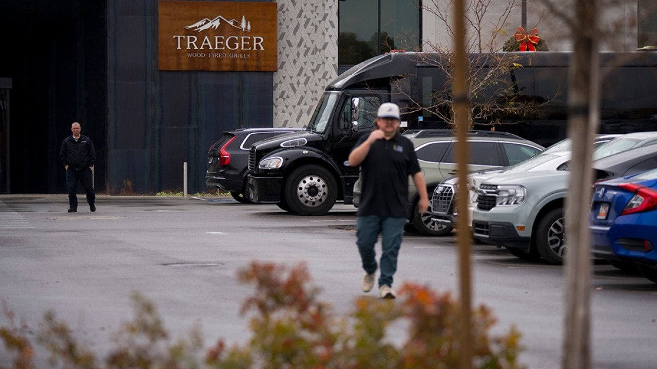 A person walking through the parking lot in the foreground with entrance to Traeger Grills Headquarters in behind, in Salt Lake City.