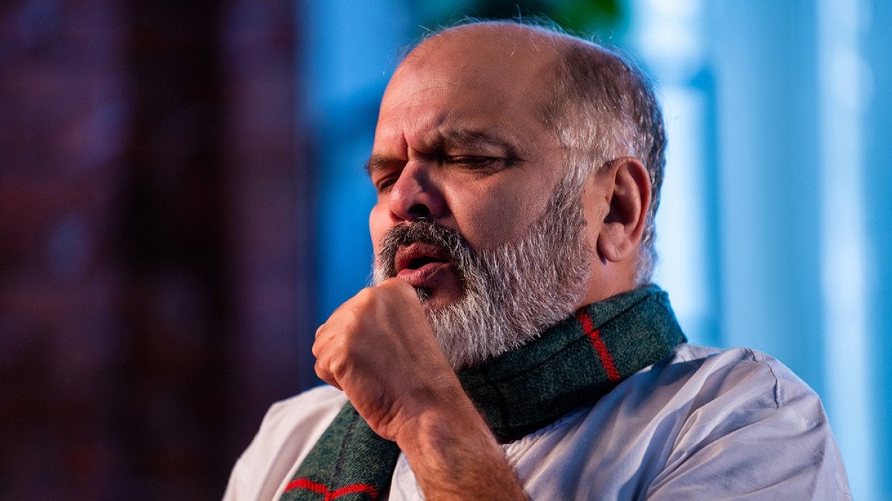 A senior man coughing.