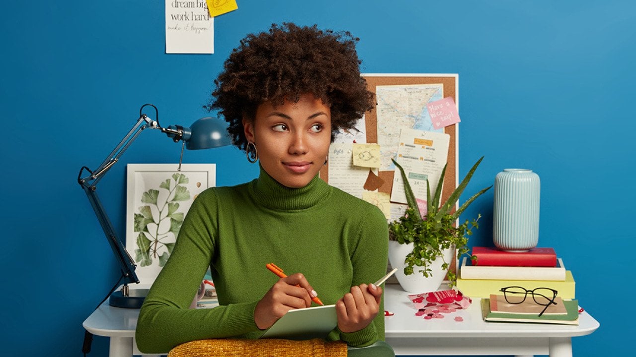 A young woman writing down plans in her notepad.