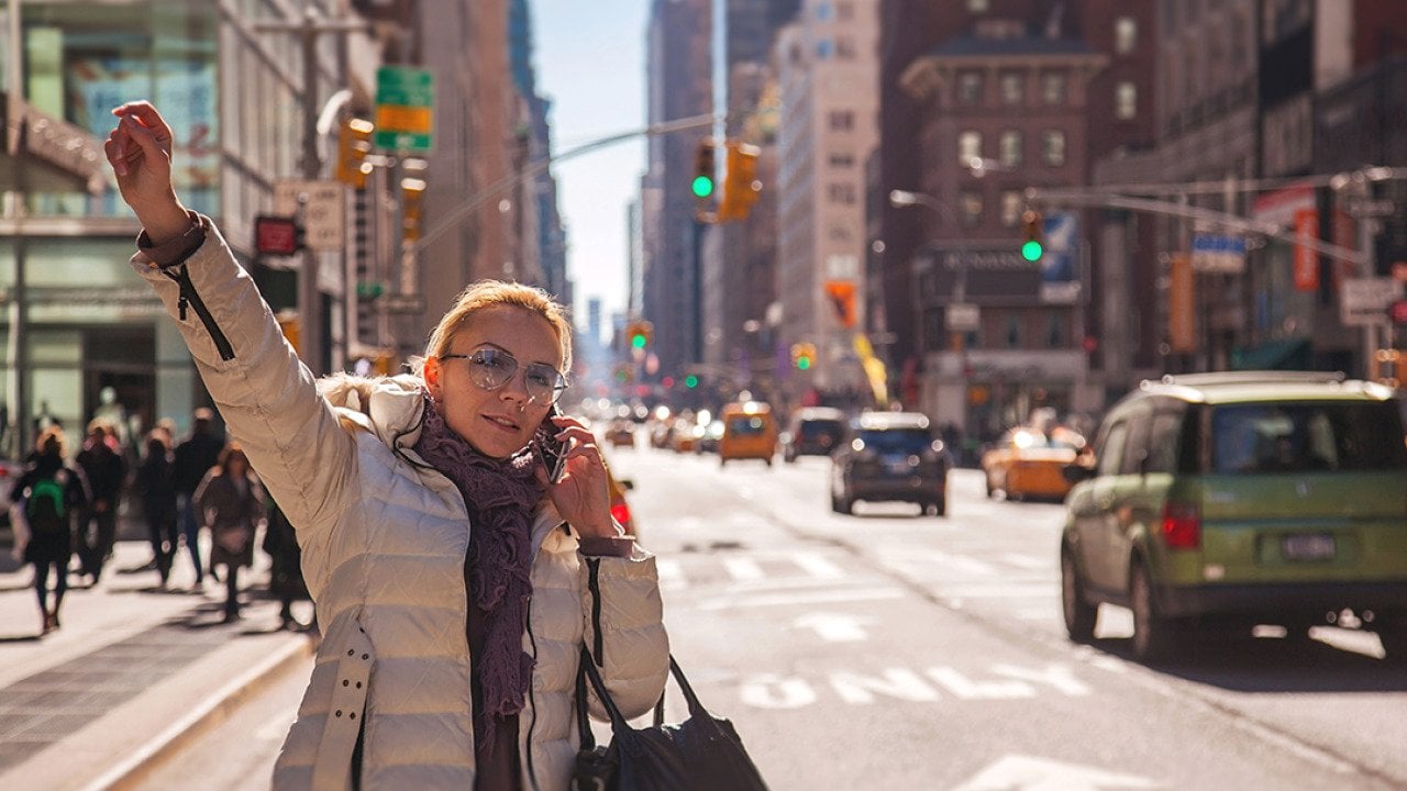 Woman signaling for a cab in New York City. 