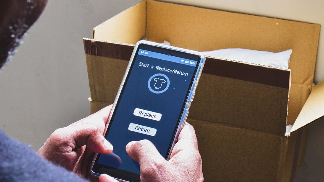 A man looking at a shopping app on his phone displaying options to replace or return a product.