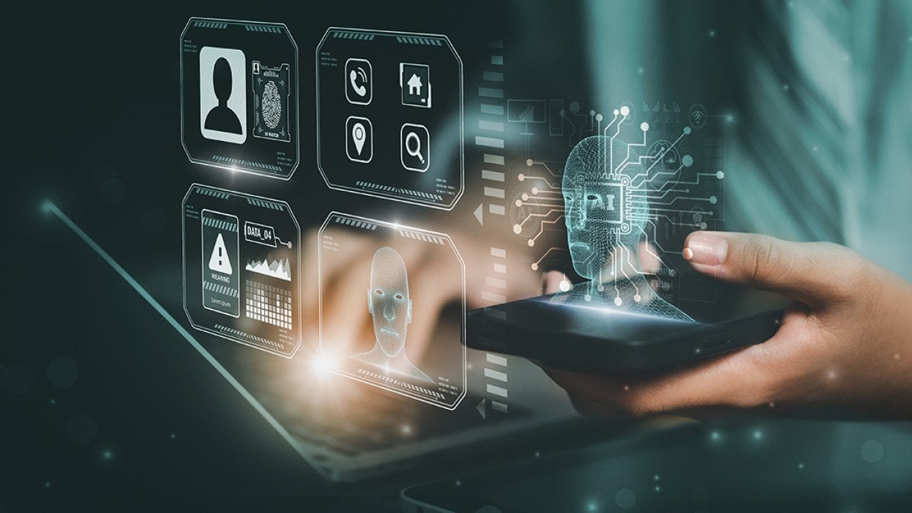 AI and facial recognition graphics illustrated over a person using a laptop and smartphone.