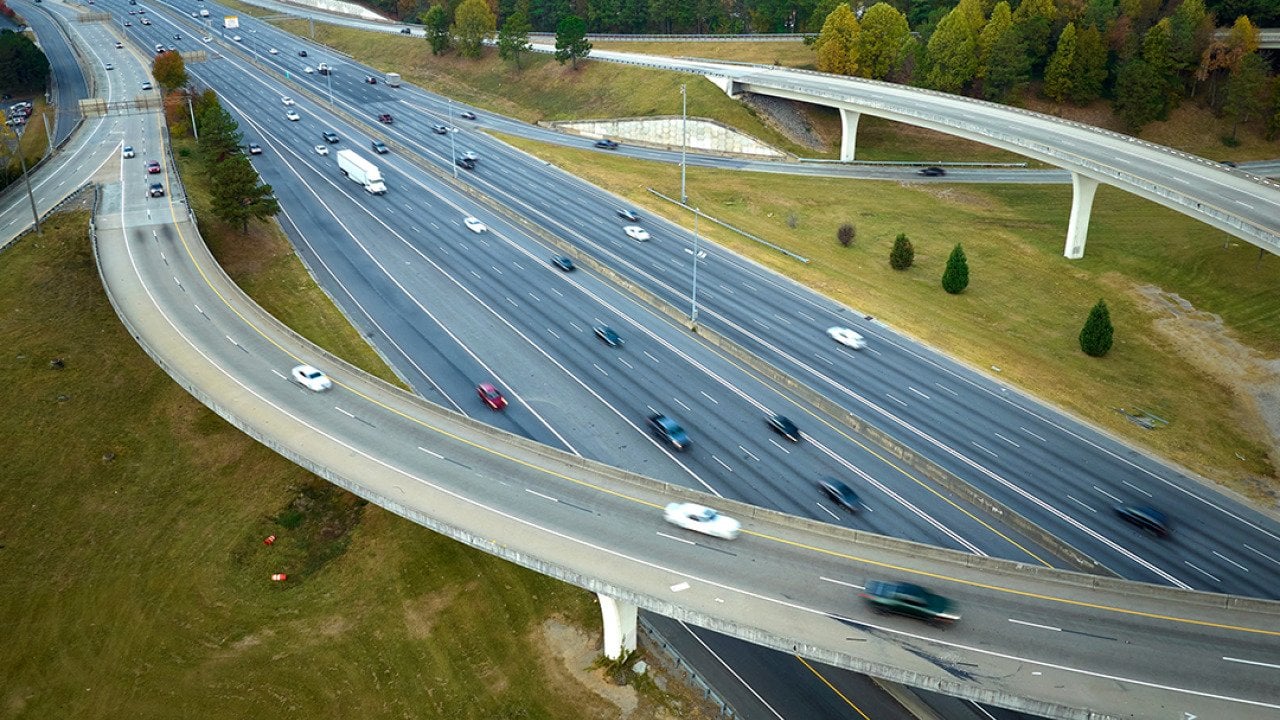 An aerial view of an American freeway intersection with fast moving trucks and cars.