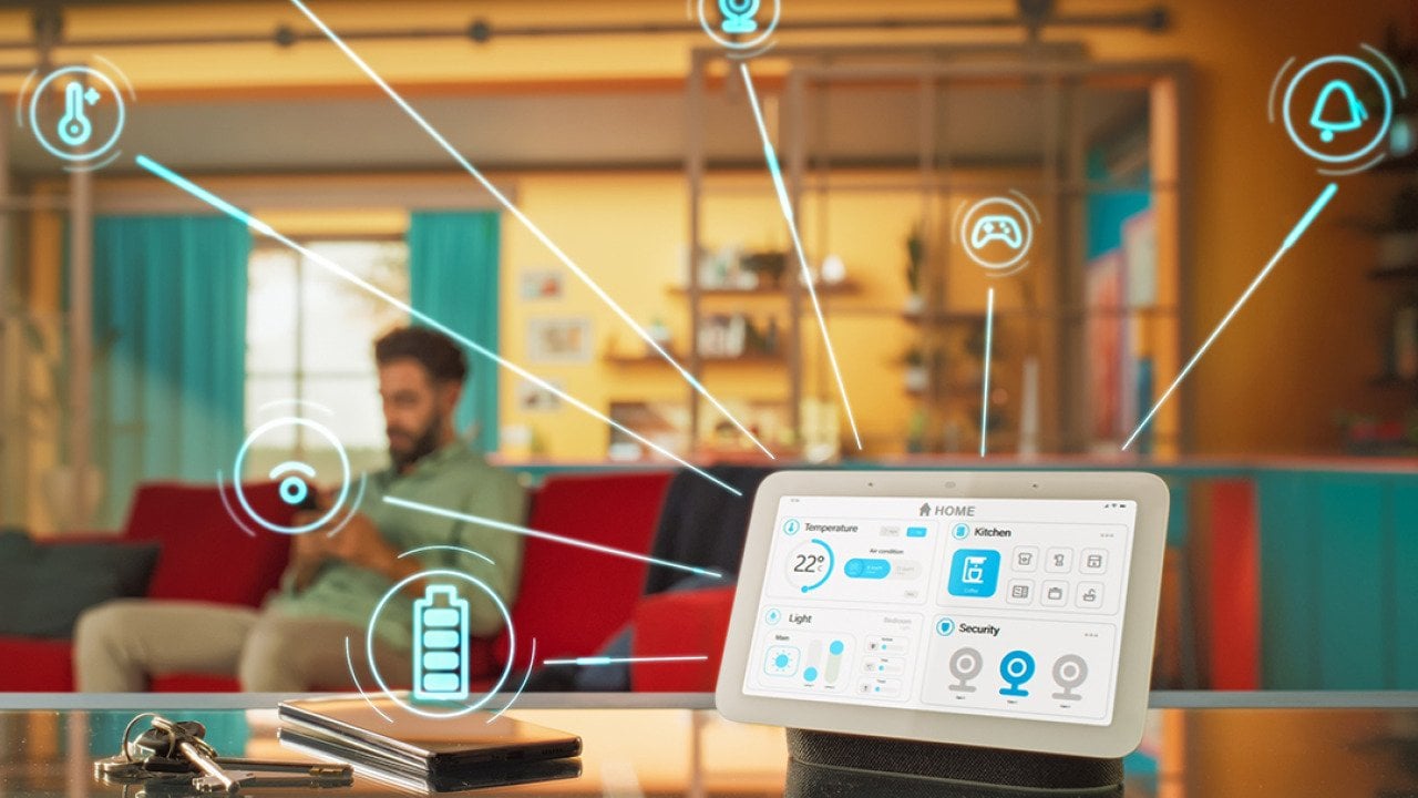 A unified home intelligence system device illustrated with apps and connectivity graphics with the homeowner in a living room as the background.