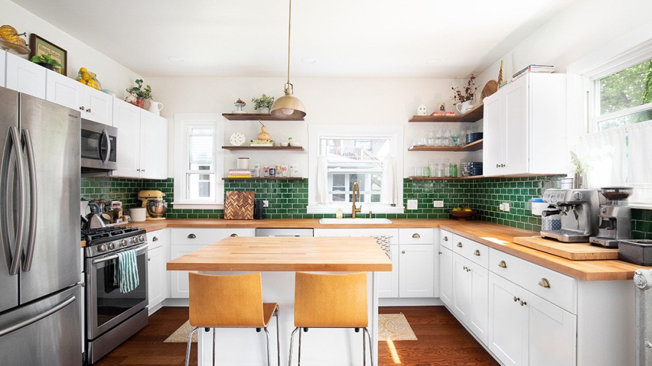 Interior of a modern kitchen with wooden and green layout motifs.