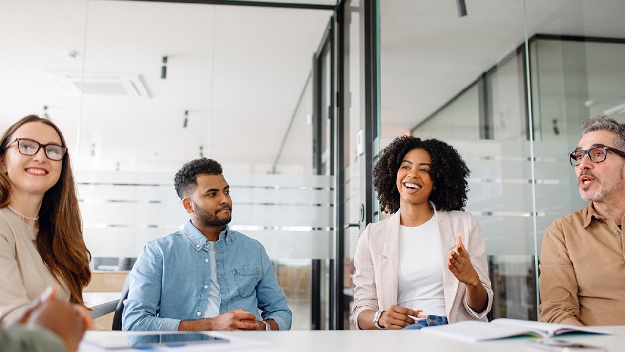 A diverse business team in a meeting room engaged in discussion.