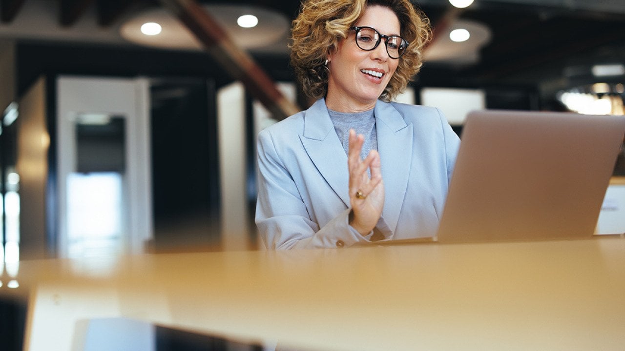 A businesswoman on a video call in an office.