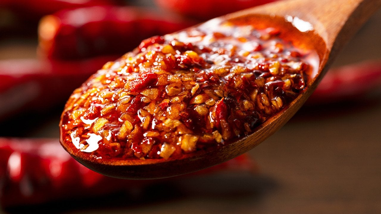 Chili oil scooped up with a wooden tablespoon.
