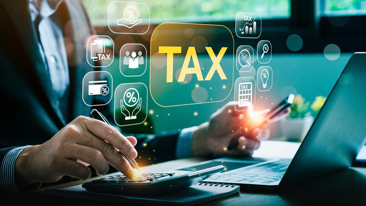 A businessman calculating taxes illustrated with tax deduction software graphics.