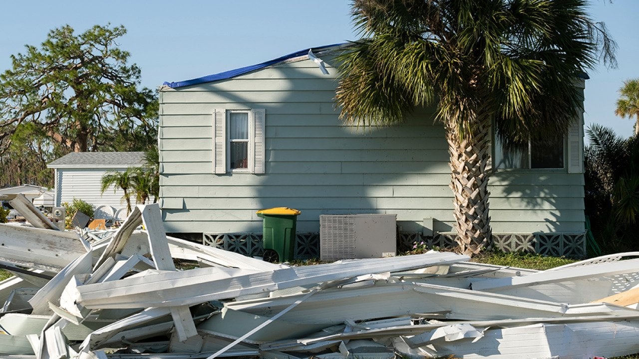 Debris on the side of a street after a hurricane in a residential area in Florida.