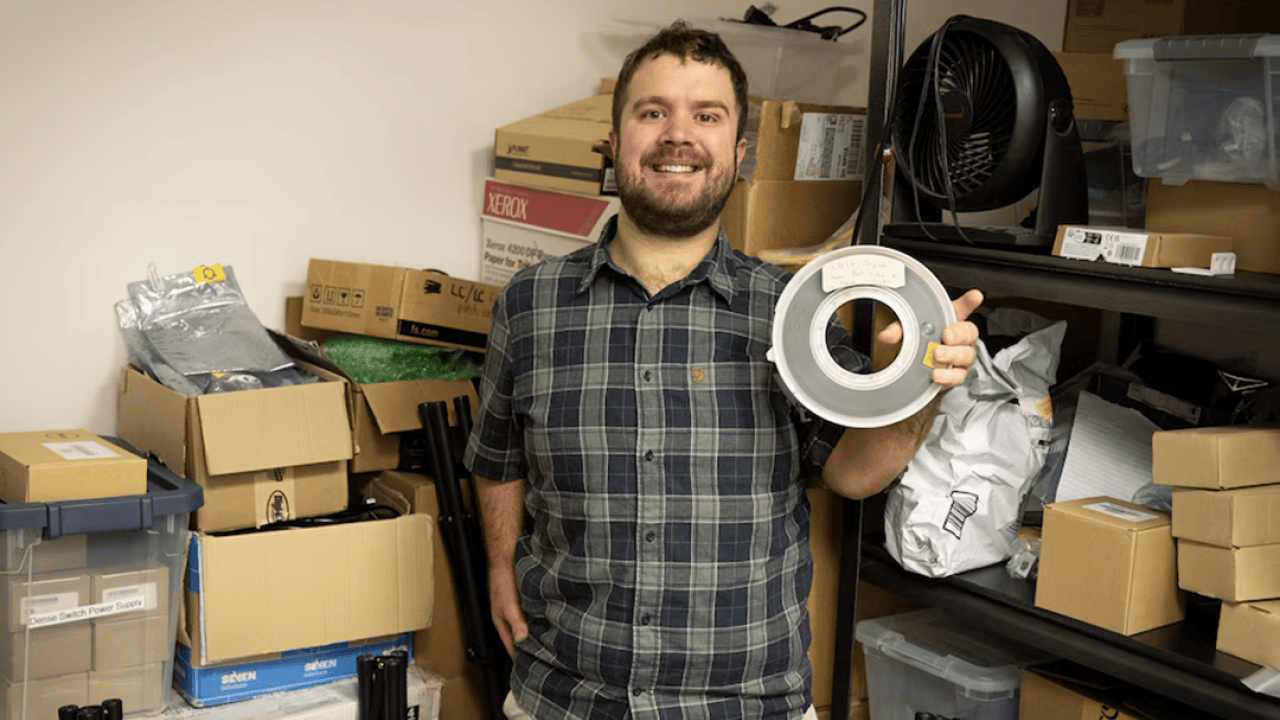 Aleks Maricq, a research associate at the University of Utah, holds the 9-track magnetic tape marked as containing a copy of UNIX Version 4, a foundational computer operating system, that he found in a storage room.