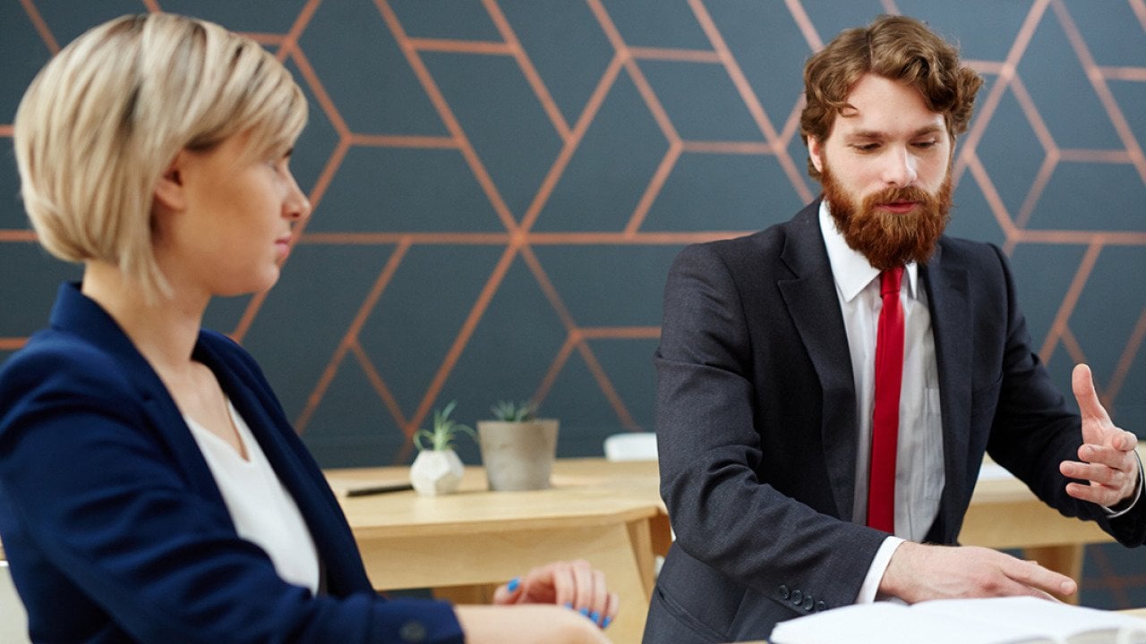 A female employee listening to her colleague at work.