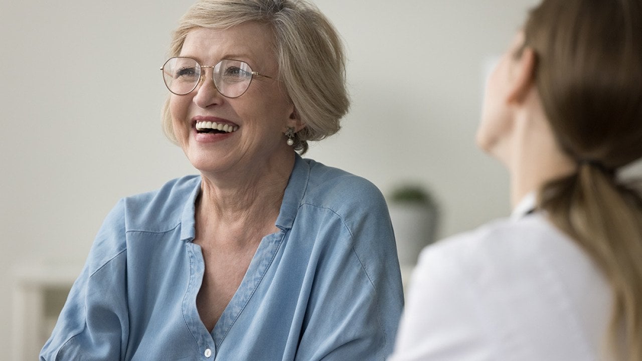 A senior woman laughing during clinic visit.