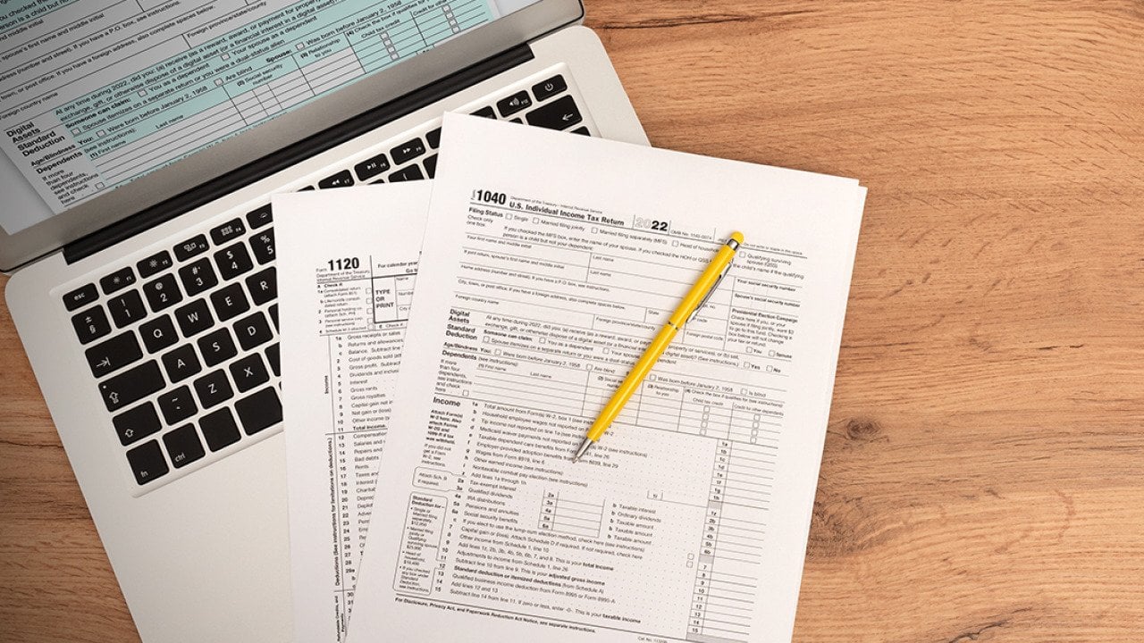 US tax form documents on top of a laptop.