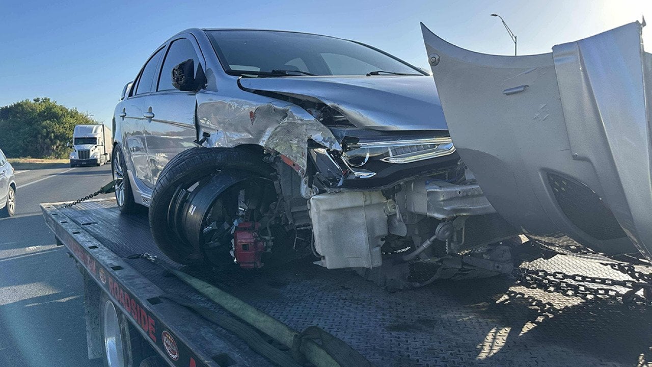 A crashed car loaded on a tow truck.