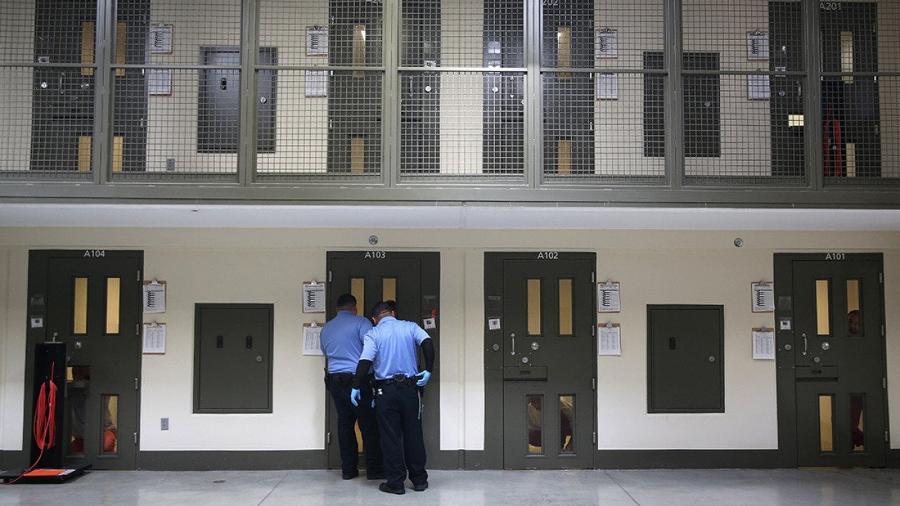 Guards prepare to escort an immigrant detainee from his 'segregation cell' back into the general population at the Adelanto Detention Facility on November 15, 2013 in Adelanto, California.