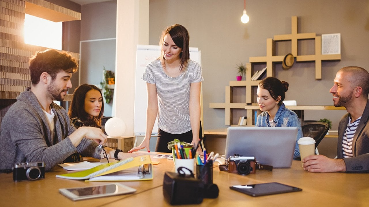 A graphic design team in a meeting room working on a project.