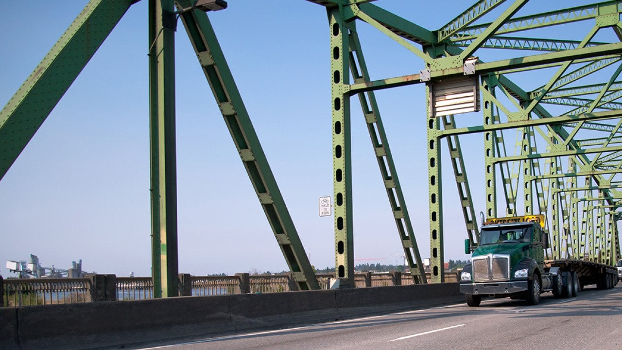 An empty transport semi truck going through a bridge.
