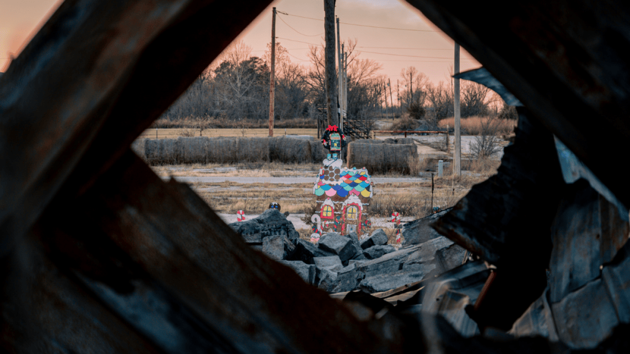 View of Christmas decorations in a parade amongst debris with a sunset in the background in Picher, Oklahoma, a town left abandoned after it was designated a superfund site due to contamination with mining waste.