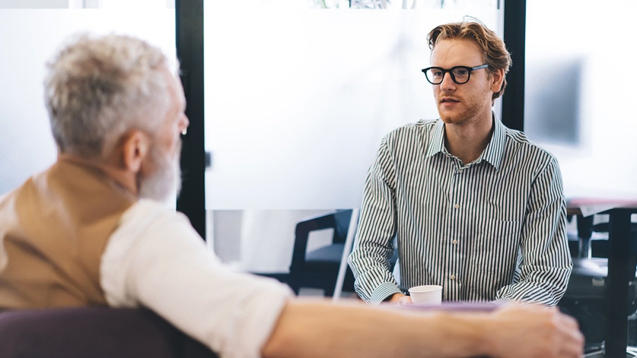 A young businessman listening to his senior manager.