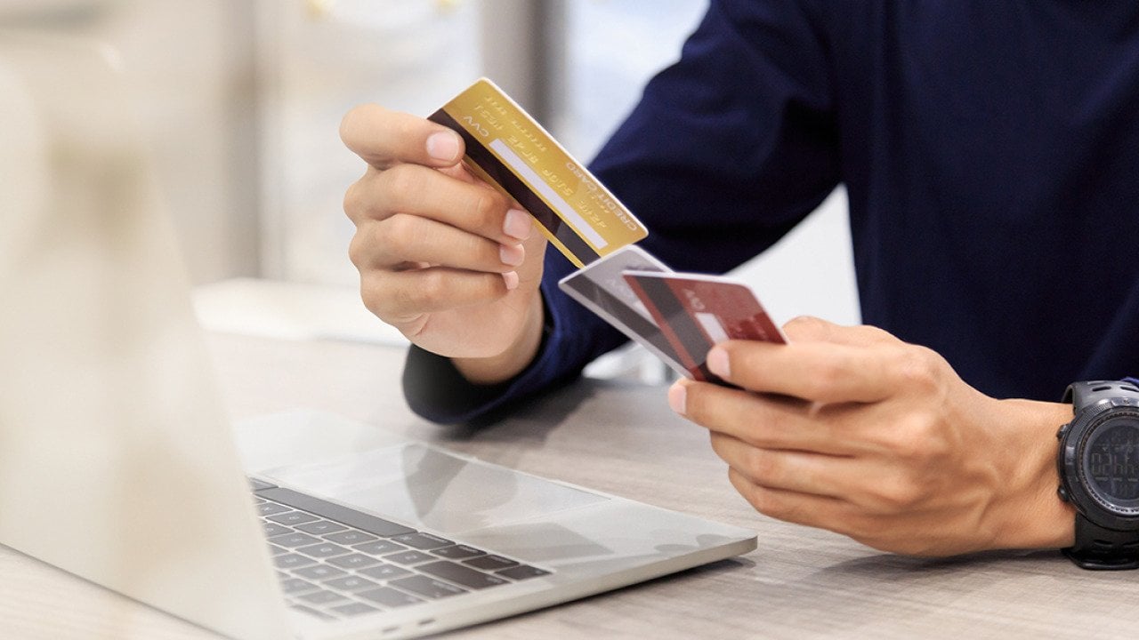 Man holding multiple credit cards.