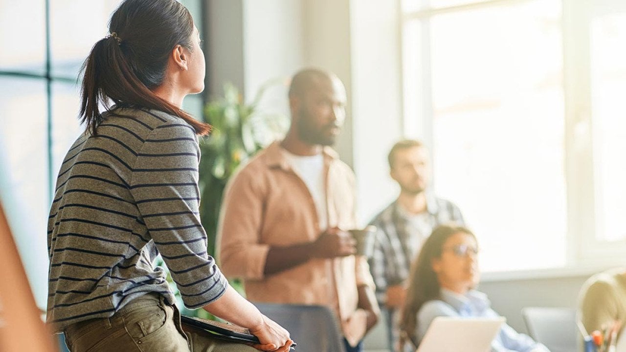 A young woman looking at her business team during a meeting in an office.