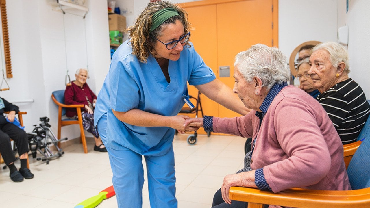 A nurse assisting one of the elderly residents of a nursing home.