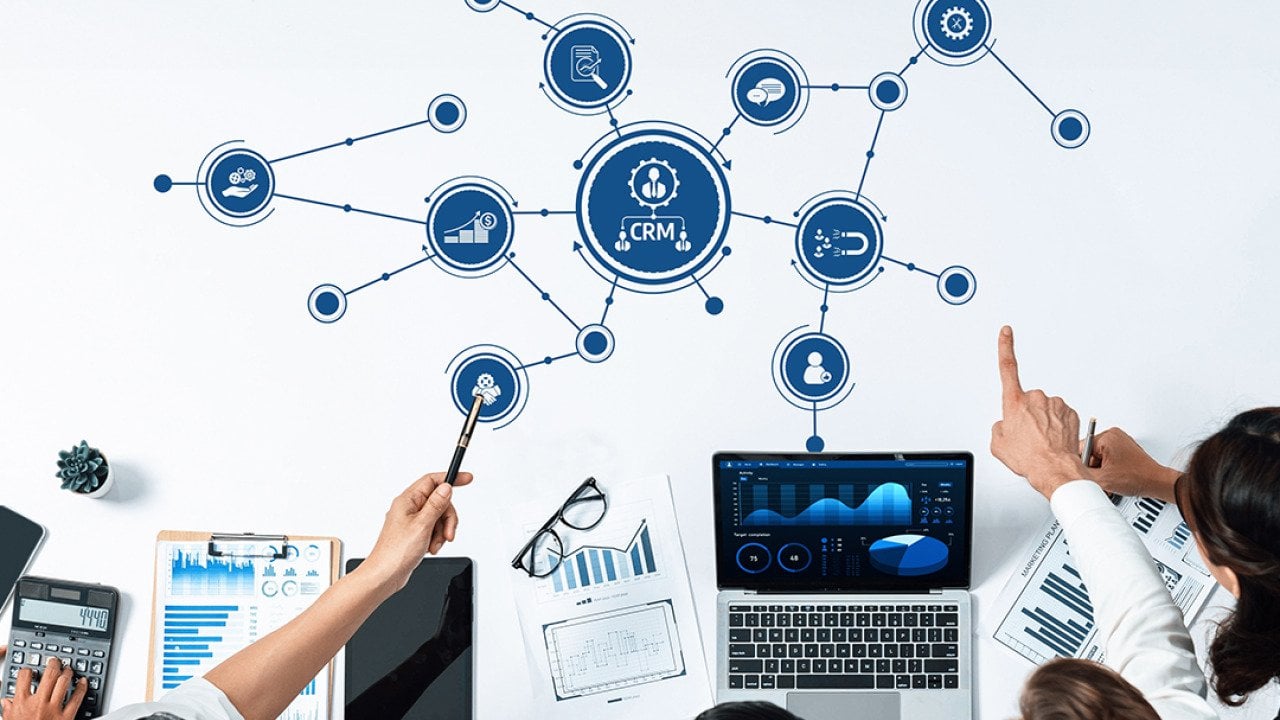 A business team collaborating and illustrated utilizing a CRM tool.