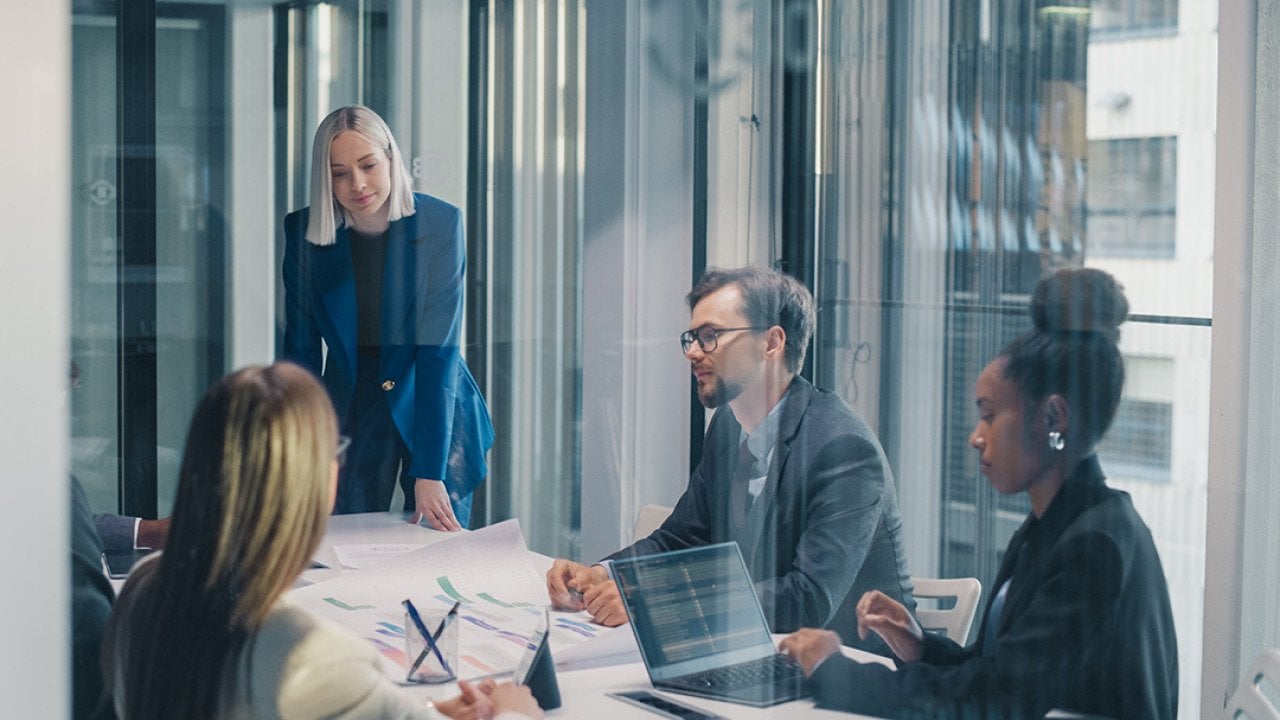A business team inside a glass meeting room.