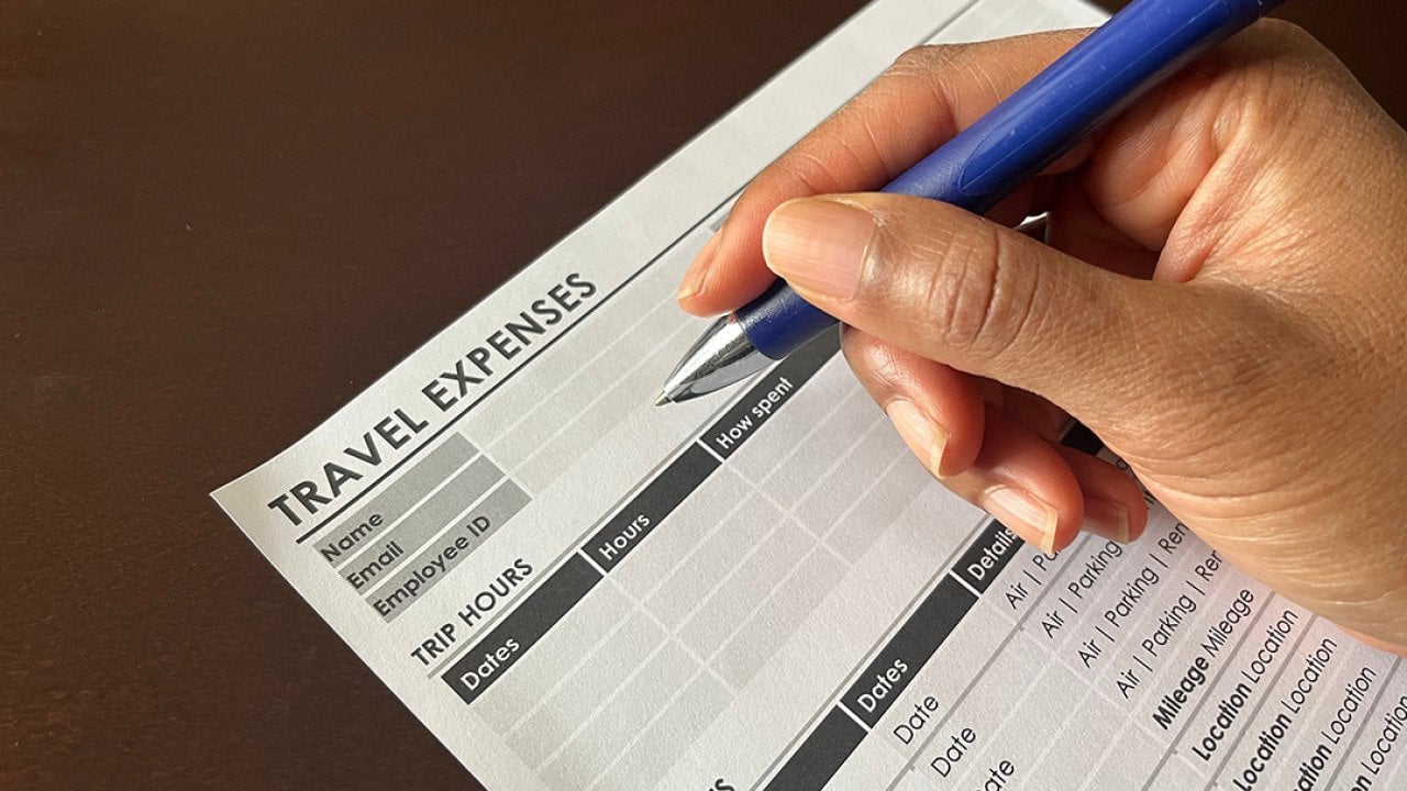 Person completing a travel expense form.