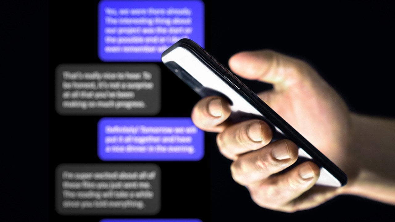 Person using a smartphone against a background of chat bubbles.